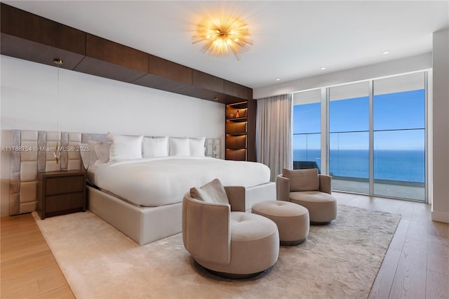 bedroom featuring a water view and wood finished floors