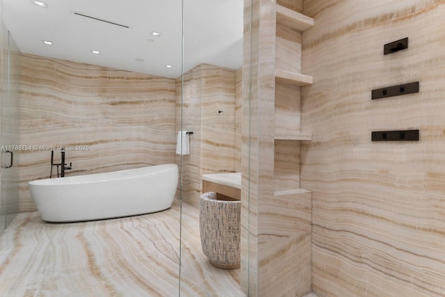 full bathroom with recessed lighting, a freestanding tub, and tile walls
