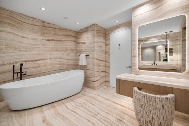 full bath with a freestanding tub, lofted ceiling, and vanity