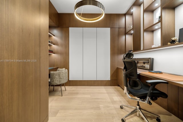 office space with built in desk and light wood-type flooring