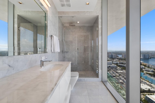 bathroom with toilet, a shower stall, a city view, and vanity