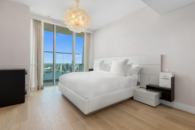 bedroom with floor to ceiling windows, light wood-type flooring, baseboards, an inviting chandelier, and access to outside