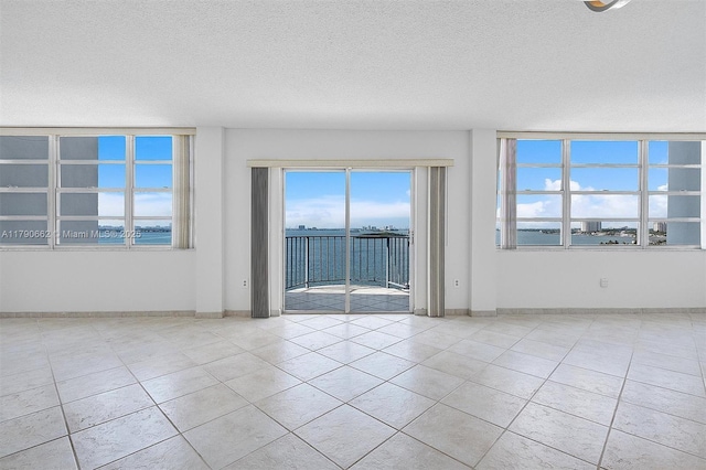 11930 N Bayshore Dr Unit 1007, North Miami, FL 33181 - tiled spare room with a textured ceiling, a wealth of natural light, and baseboards