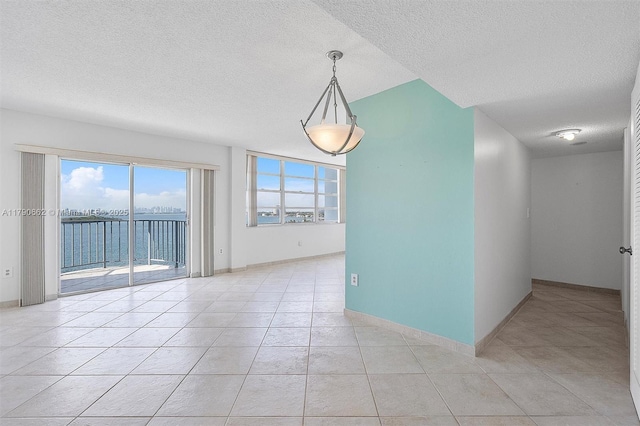11930 N Bayshore Dr Unit 1007, North Miami, FL 33181 - spare room featuring baseboards, a textured ceiling, and light tile patterned flooring