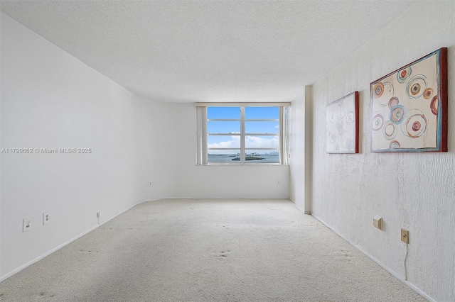 11930 N Bayshore Dr Unit 1007, North Miami, FL 33181 - empty room featuring a textured ceiling, carpet flooring, and baseboards