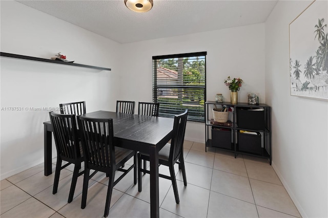 dining space featuring baseboards and light tile patterned floors