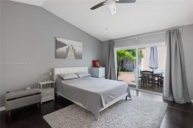 bedroom with a textured ceiling, dark wood-style floors, vaulted ceiling, and access to exterior