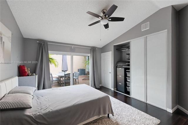bedroom featuring a textured ceiling, visible vents, dark wood-style floors, lofted ceiling, and access to outside