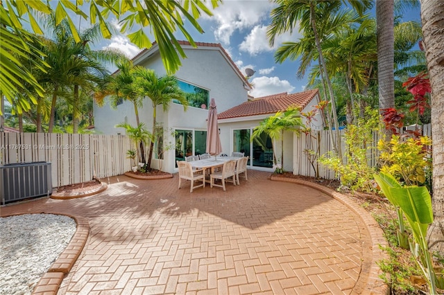 view of patio featuring outdoor dining area, central AC unit, and fence