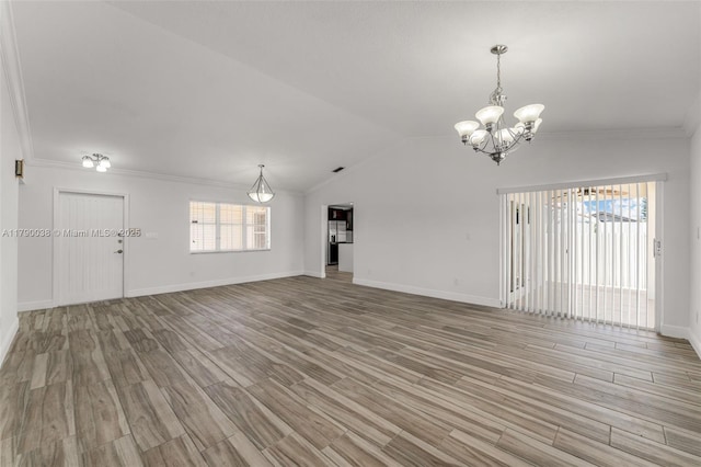 unfurnished living room featuring light wood finished floors, ornamental molding, a notable chandelier, and baseboards