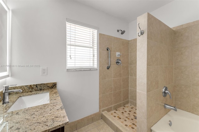 bathroom with tile patterned floors, tiled shower / bath, and vanity
