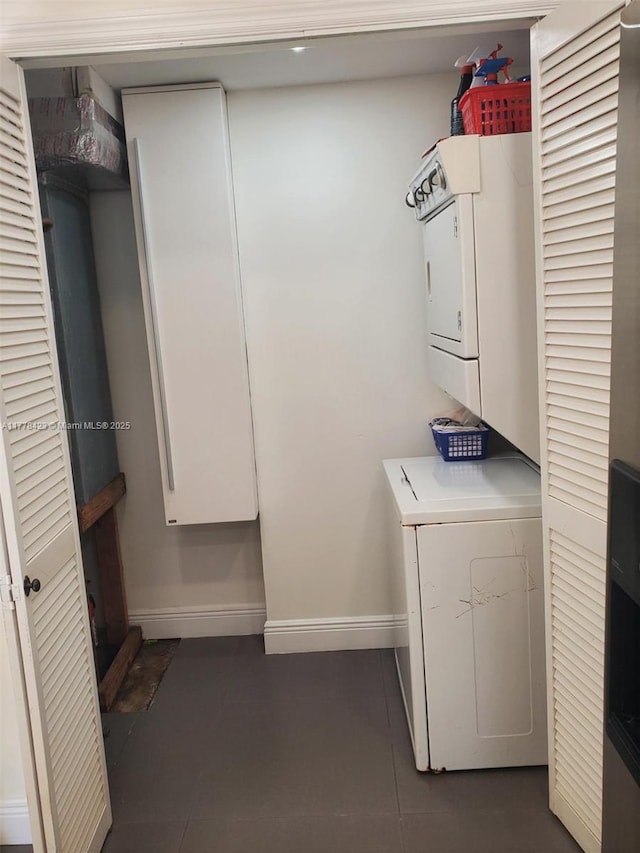 301 Bonaventure Blvd Unit 6, Weston, FL 33326 - clothes washing area with stacked washer / drying machine, dark tile patterned floors, laundry area, and baseboards