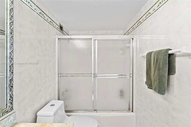 5601 Collins Ave Unit 1014, Miami Beach, FL 33140 - bathroom with bath / shower combo with glass door, toilet, tile walls, and visible vents