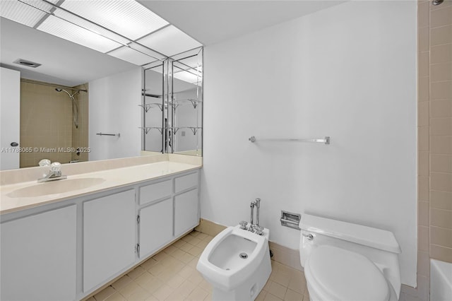bathroom with baseboards, toilet, a bidet, vanity, and tile patterned flooring