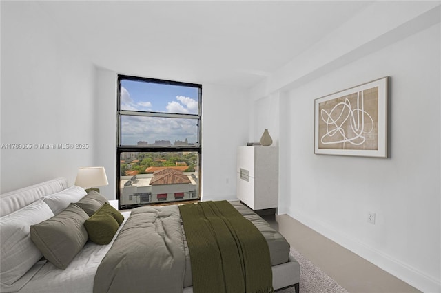 bedroom featuring a wall of windows and baseboards