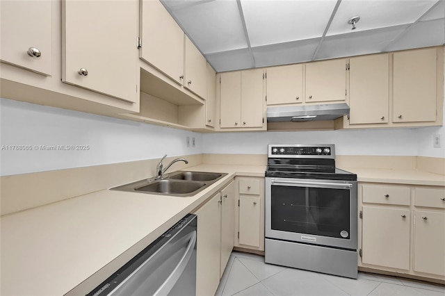 kitchen with a sink, stainless steel appliances, under cabinet range hood, cream cabinets, and light countertops