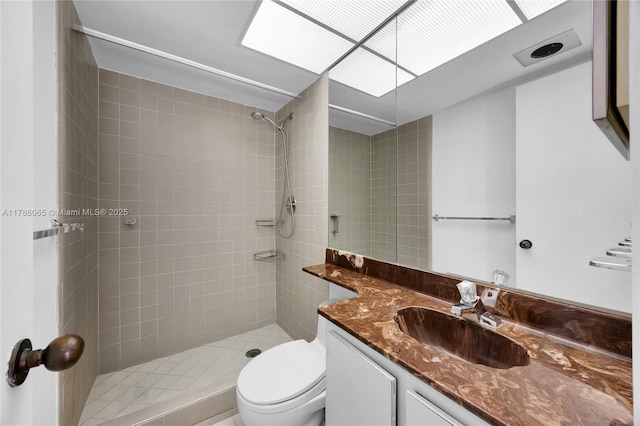 bathroom featuring vanity, toilet, and tiled shower