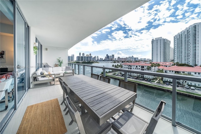 balcony with outdoor lounge area, a water view, and a city view