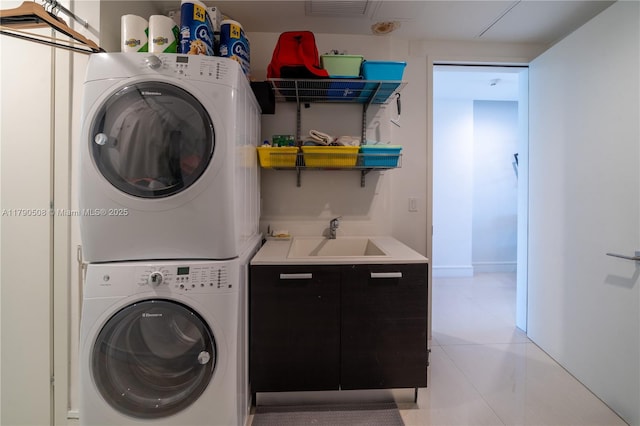 laundry room featuring a sink, stacked washing maching and dryer, light tile patterned flooring, laundry area, and visible vents