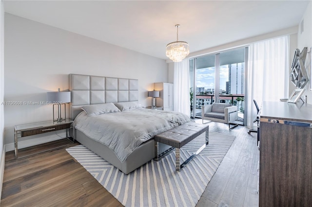 bedroom with access to outside, wood finished floors, and a chandelier