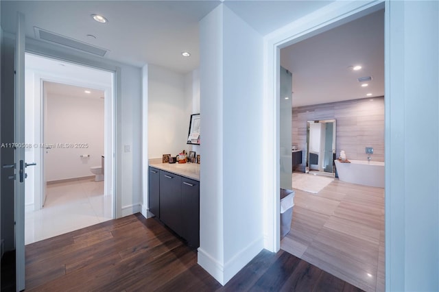 corridor featuring baseboards, recessed lighting, visible vents, and dark wood-style flooring