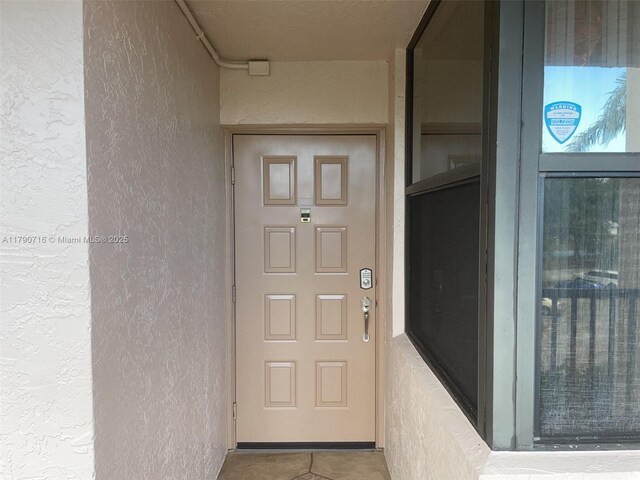doorway to property featuring stucco siding