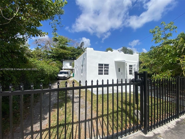 view of front facade with fence and stucco siding