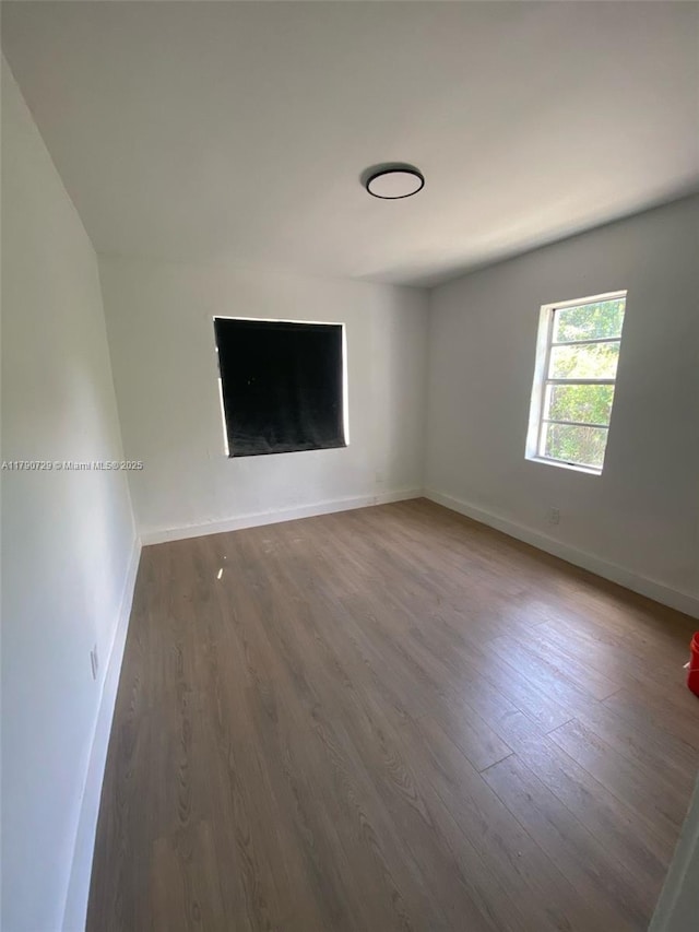 unfurnished room featuring baseboards and wood finished floors