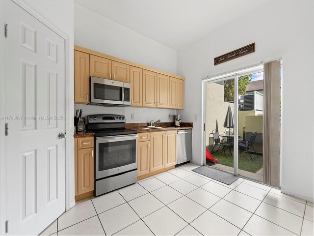 2352 SE 21st St, Homestead, FL 33035 - kitchen with light brown cabinetry, light tile patterned floors, stainless steel appliances, and a sink