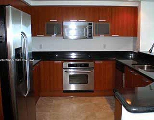 15051 Royal Oaks Ln Unit 2301, North Miami, FL 33181 - kitchen featuring appliances with stainless steel finishes, brown cabinets, dark countertops, and modern cabinets