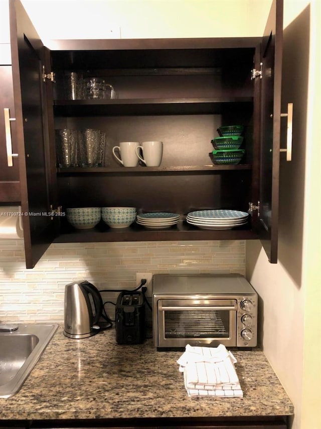 79 Lyndhurst Unit D, Deerfield Beach, FL 33442 - details featuring a toaster, backsplash, a sink, and open shelves