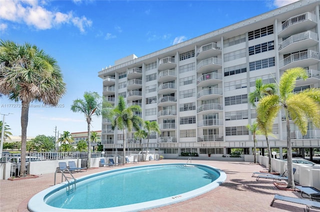 community pool featuring a patio and fence