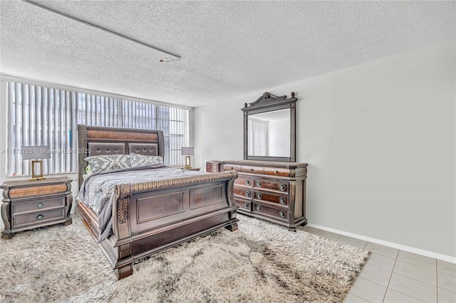 tiled bedroom with a textured ceiling and baseboards