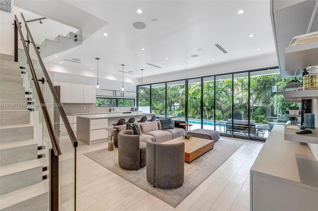 1311 Bay Dr, Miami Beach, FL 33141 - living room featuring visible vents, stairway, and light wood-style floors