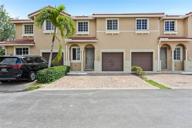 21421 NW 13th Ct Apt 211, Miami Gardens, FL 33169 - view of front of property with a tile roof, driveway, an attached garage, and stucco siding