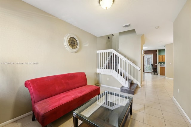 21421 NW 13th Ct Apt 211, Miami Gardens, FL 33169 - living area featuring tile patterned floors, visible vents, baseboards, and stairs