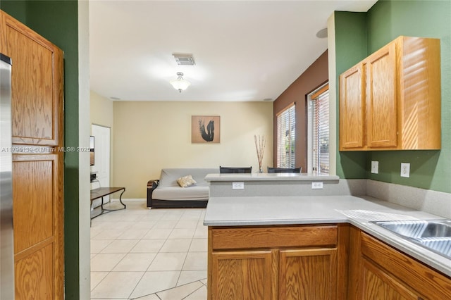 21421 NW 13th Ct Apt 211, Miami Gardens, FL 33169 - kitchen with a sink, light tile patterned flooring, visible vents, a peninsula, and light countertops