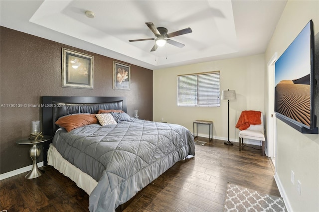 21421 NW 13th Ct Apt 211, Miami Gardens, FL 33169 - bedroom featuring ceiling fan, a tray ceiling, a textured wall, baseboards, and wood finished floors