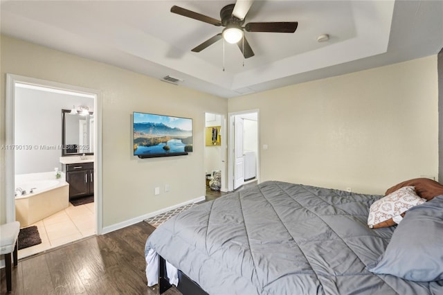 21421 NW 13th Ct Apt 211, Miami Gardens, FL 33169 - bedroom featuring wood finished floors, connected bathroom, visible vents, a ceiling fan, and a tray ceiling