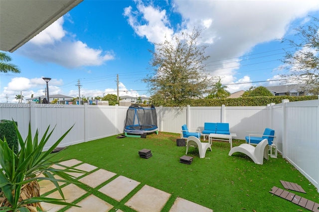 view of yard with a fenced backyard and a trampoline