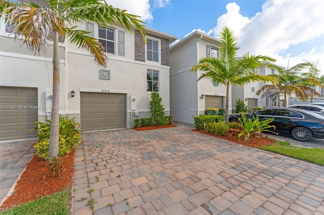 view of front of house with decorative driveway, stucco siding, and a garage
