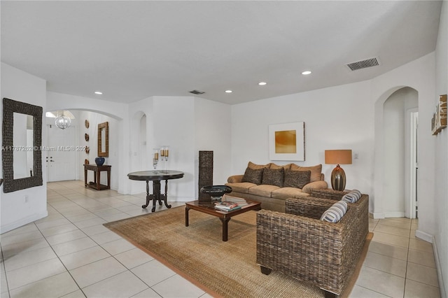 living room with light tile patterned floors, arched walkways, and visible vents