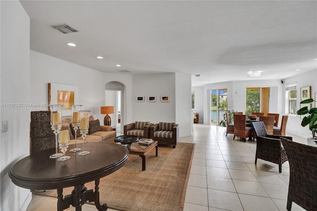living area with visible vents, arched walkways, light tile patterned floors, and recessed lighting