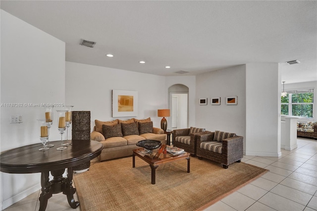 living room featuring visible vents, arched walkways, light tile patterned flooring, and recessed lighting