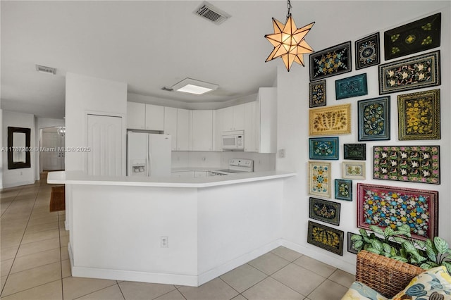 kitchen featuring light tile patterned floors, white appliances, visible vents, a peninsula, and light countertops