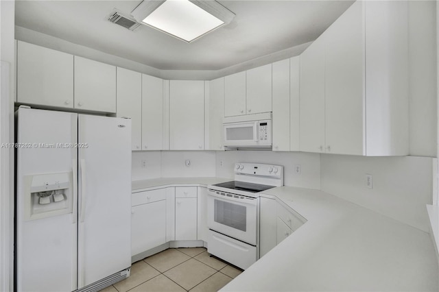 kitchen featuring light countertops, light tile patterned flooring, visible vents, and white appliances