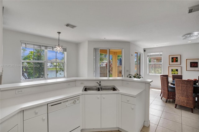 kitchen featuring a sink, white dishwasher, a wealth of natural light, and visible vents