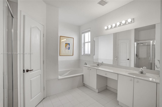 bathroom featuring tile patterned floors, a sink, visible vents, a stall shower, and a garden tub