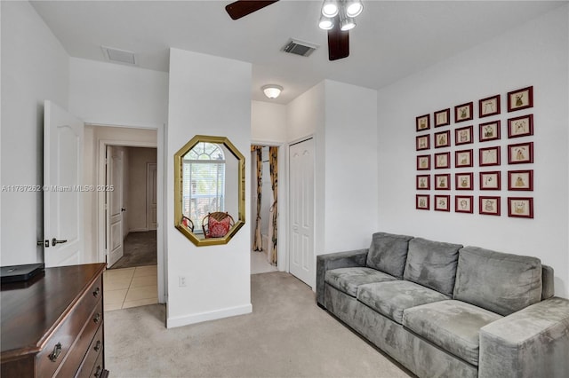 living room with visible vents, a ceiling fan, light carpet, and baseboards