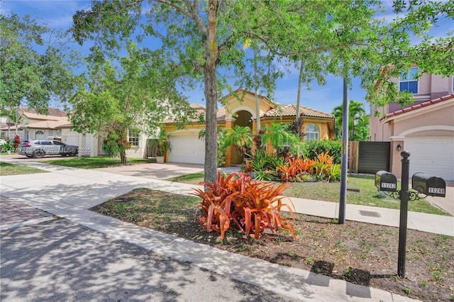 mediterranean / spanish house featuring stucco siding, a tile roof, concrete driveway, and an attached garage